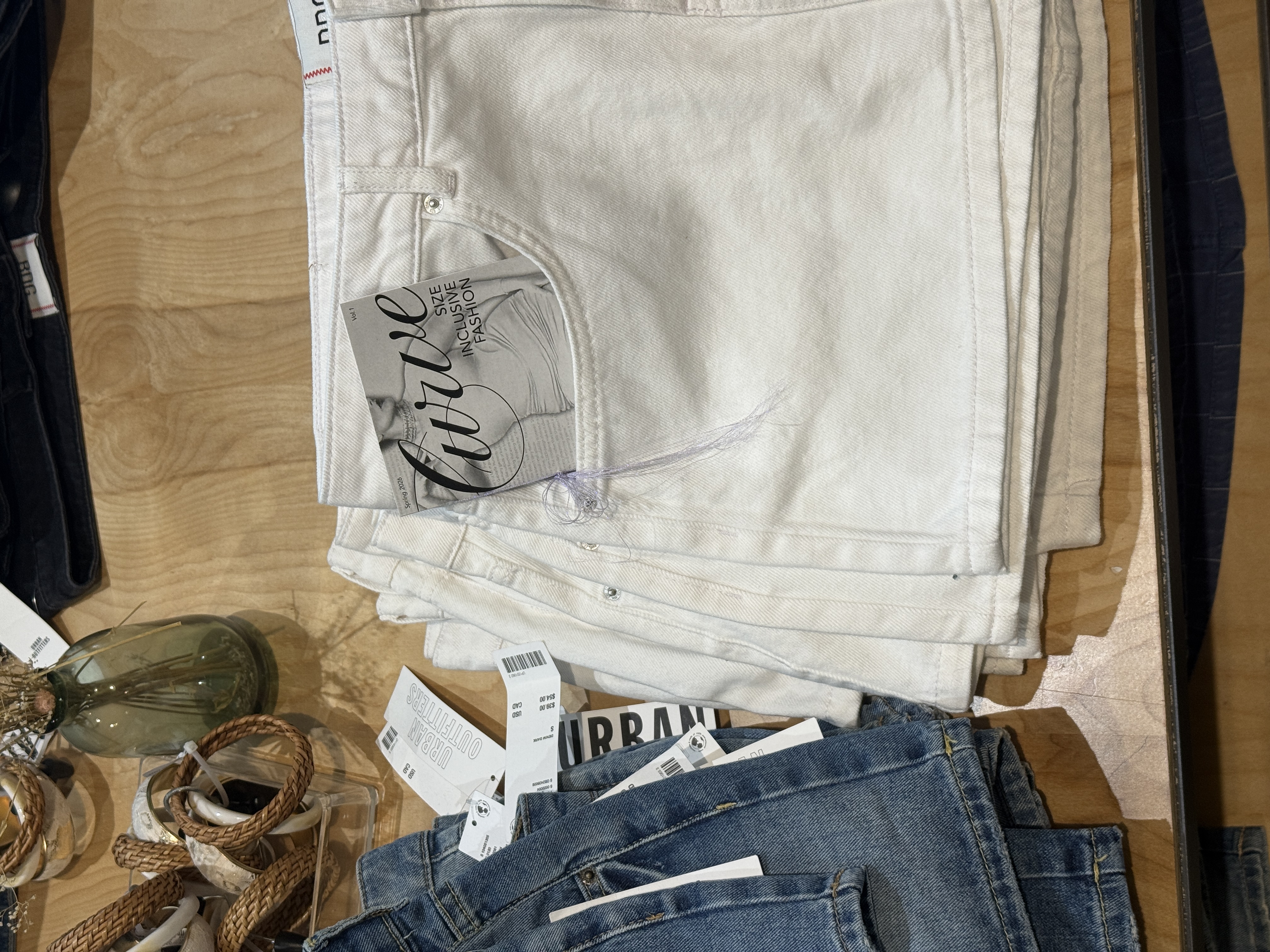 Zine placed white denim mini skirt front pocket at urban outfitters sitting on table